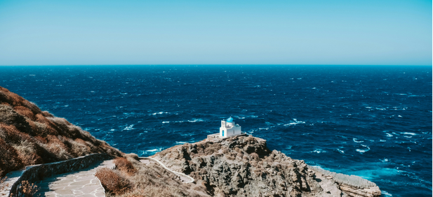 Petite chapelle blanche sur une falaise à Sifnos, vue sur la mer Égée