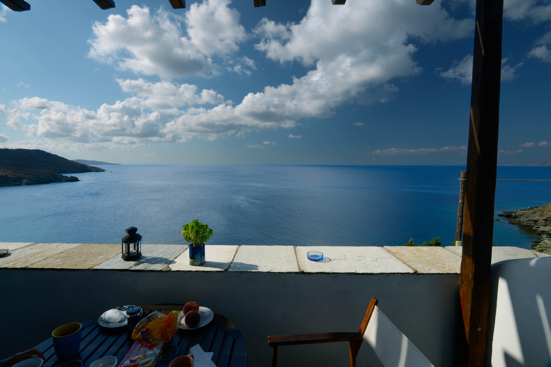 Petit-déjeuner sur une terrasse cycladique avec vue sur la mer Égée, ambiance sereine pour un voyage en Grèce en famille